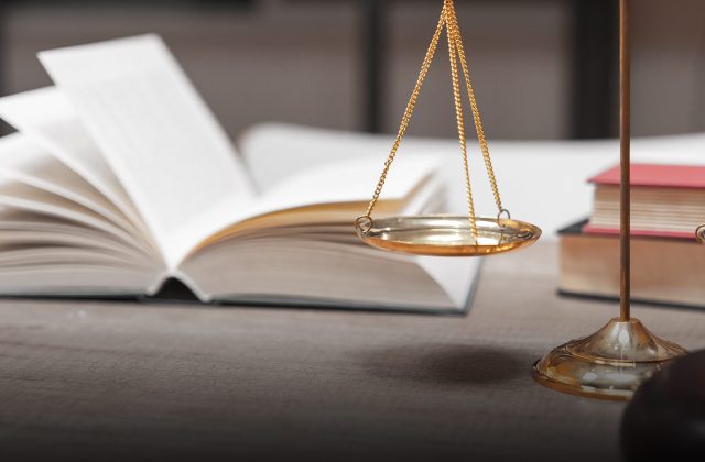 Close-Up Of Weight Scale And Gavel On Table